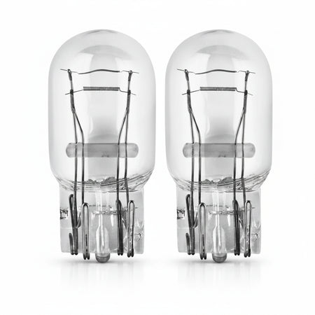 Two clear automotive light bulbs on a white background